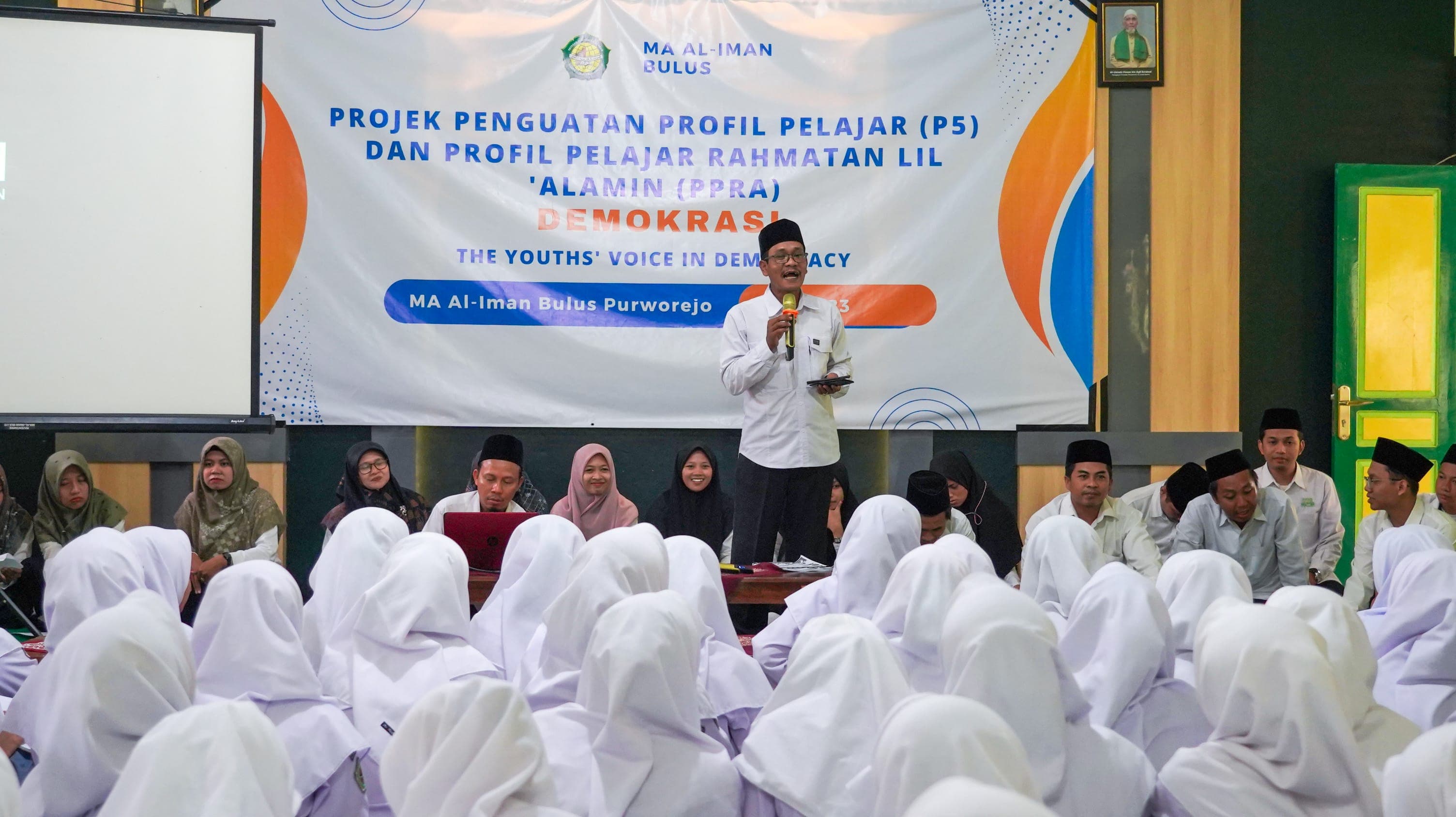 Foto dokumentasi acara "Projek Penguatan Profil Pelajar (P5) Dan Profil Pelajar Rahmatan Lil Alamin (PPRA) Demokrasi The Youth's Voice in Democracy" yang diikuti oleh jajaran guru dan siswi Madrasah Aliyah Al-Iman Bulus Purworejo. Dokumentasi Al-Iman Media 2023